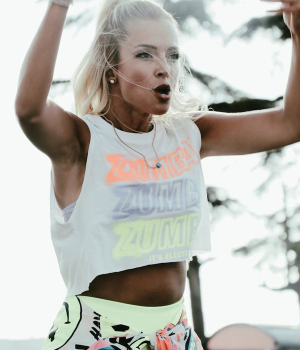 Woman performing a dynamic cardio movement with a serene expression.